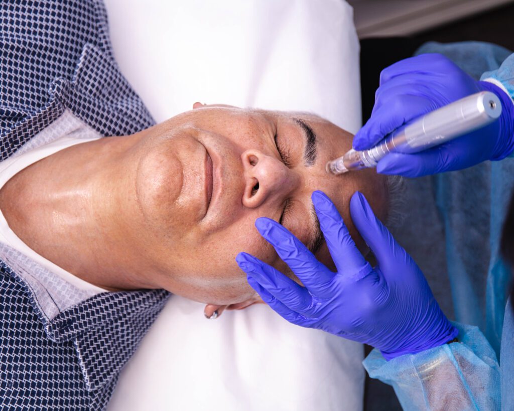 2C8A4997 (1) A man getting his face waxed by an esthetician.